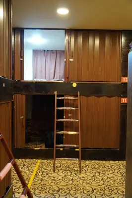 a bunk bed in a room with a ladder at Petra voyager Hostel in Wadi Musa