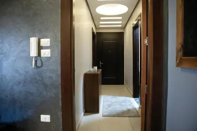 a hallway leading to a bathroom with a black door at Alghalayieny Modern Apartments in Amman