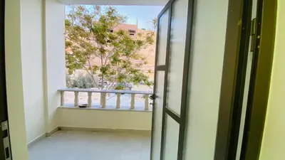 an open door with a view of a balcony at Petra Olive House in Wadi Musa