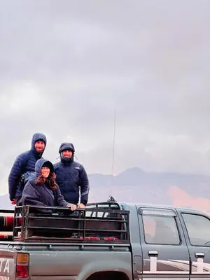 three people sitting in the back of a truck at Wadi Rum Local Guide in Wadi Rum