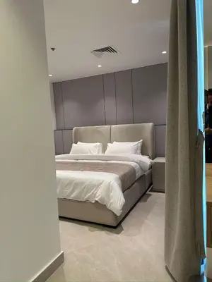 a bedroom with a large bed with white sheets at Damac Tower Amman - Luxury Studio - استوديوهات فاخرة - داماك عمان العبدلي in Amman