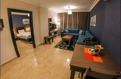 a living room with a blue couch and a bed at Ibiza Hotel in Amman