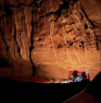 a group of people sitting in a cave at Bedouin Desert Life Camp & Jeep Tours in Wadi Rum