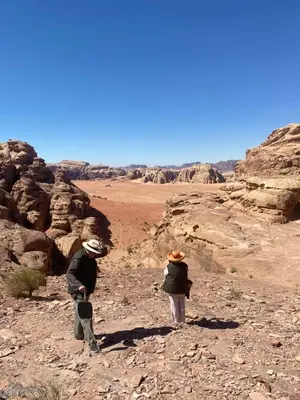 two people walking through the desert at Wadirum Zeid Classic camp in Wadi Rum