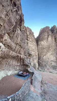 a rock cave with a table in the middle of it at Wadirum Zeid Classic camp in Wadi Rum