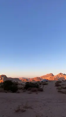 a view of the desert with cars in the distance at Wadirum Zeid Classic camp in Wadi Rum
