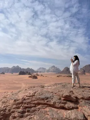 a woman taking a picture of the desert at Wadi Rum Star Camp in Wadi Rum