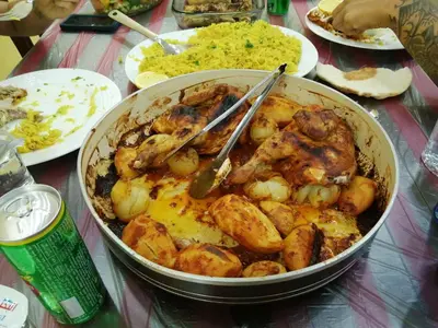 a pot of food with meat and potatoes on a table at family studio in Wadi Musa