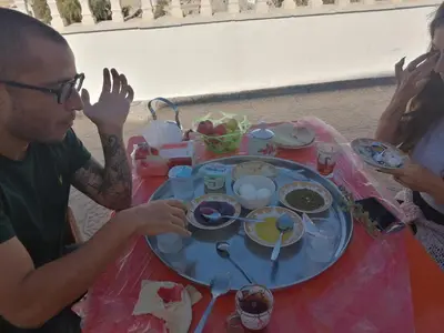 a group of people sitting at a table eating food at family studio in Wadi Musa