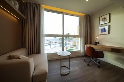 a living room with a couch and a table and a window at Luxotel Aqaba Beach Resort & Spa Only 15 years plus in Aqaba