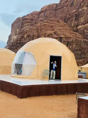 a man standing inside of a dome tent in the desert at Wadi Rum beautiful time in Wadi Rum