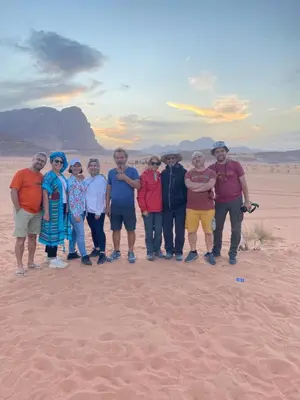 a group of people posing for a picture in the desert at Wadi Rum beautiful time in Wadi Rum
