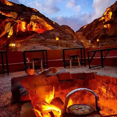 a fire pit in a desert with a table and chairs at Wadi rum under stars in Wadi Rum
