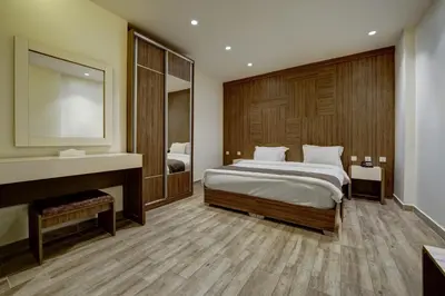 a bedroom with a large bed and a mirror at Luciana Hotel by FHM in Aqaba