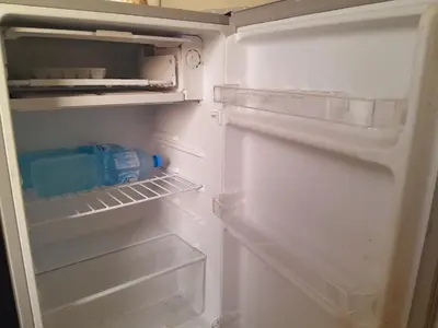 an open refrigerator with a bottle of water in it at Aun Wadi Rum Camp in Wadi Rum