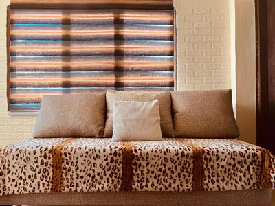 a couch with two pillows sitting in front of a window at IBN Khaldoon in Madaba