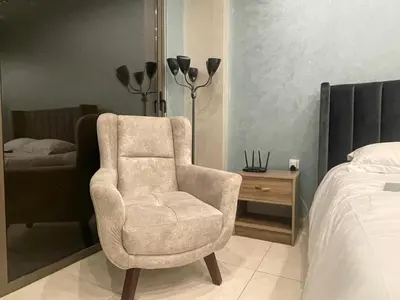 a bedroom with a chair next to a bed at Al Raha Village - Aqaba in Aqaba
