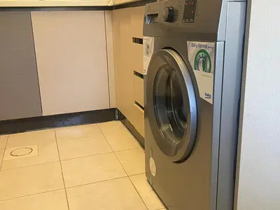 a washing machine in a room with a tile floor at Al Raha Village - Aqaba in Aqaba
