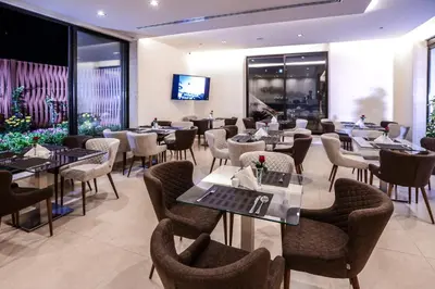 a restaurant with tables and chairs and a television at Khuttar Apartment in Amman