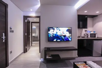 a living room with a flat screen tv on a wall at Khuttar Apartment in Amman