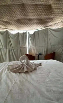 a white bed with a dress on top of it at Star Magic Camp in Wadi Rum