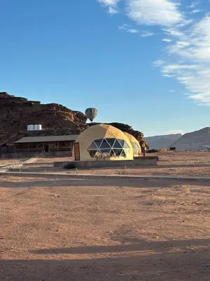 a building in the middle of a dirt field at Night Magic Camp in Wadi Rum
