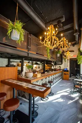 a restaurant with a table and chairs and a chandelier at Hotel Philosophy in Amman