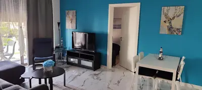 a living room with a tv and a blue wall at Blue Diamond Ayla - Restricted to Family stays in Aqaba