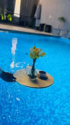 a tray with a vase with flowers on it in a pool at laperla chalet villa di lusso deadsea in Sowayma