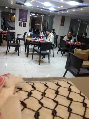 a group of people sitting at tables in a restaurant at Rose city inn in Wadi Musa