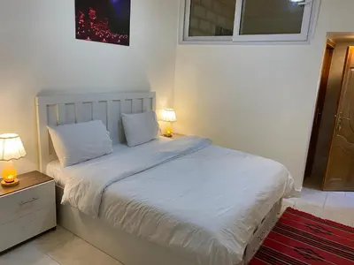 a bedroom with a white bed with two lamps on it at Rose city inn in Wadi Musa