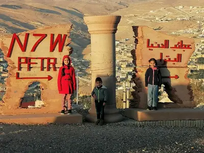 a group of three people standing in front of a building at Rose city inn in Wadi Musa
