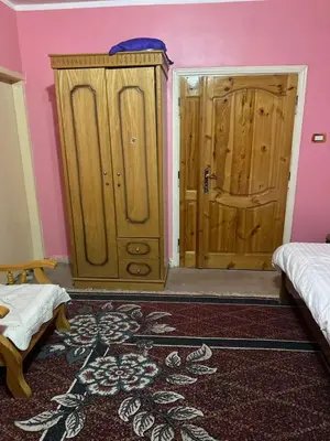 a room with two beds and two wooden doors at Jordanian Baity Apartment in Wadi Musa