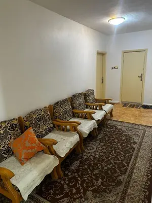 a row of couches in a room with a rug at Jordanian Baity Apartment in Wadi Musa