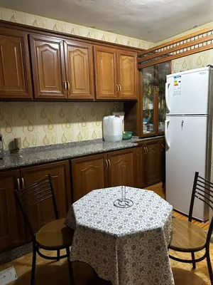 a kitchen with a table and a white refrigerator at Jordanian Baity Apartment in Wadi Musa