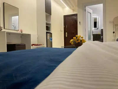 a bedroom with a large bed with a blue blanket at Uptown Hotel Apartment in Amman