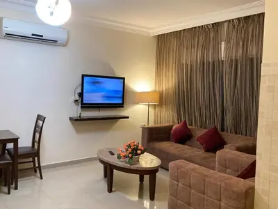 a living room with a couch and a tv at Uptown Hotel Apartment in Amman