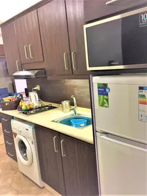 a kitchen with a sink and a stove and a refrigerator at The Royal Luxury Superior Queen cot in Amman