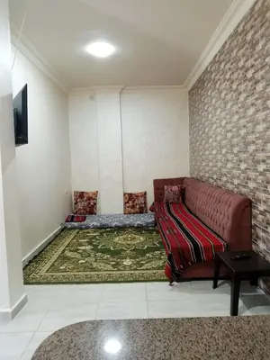 a living room with a brown leather couch and a rug at Jerash air apartment in Jerash