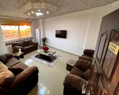 a living room with leather couches and a tv at Petra Cloud 1977 in Wadi Musa