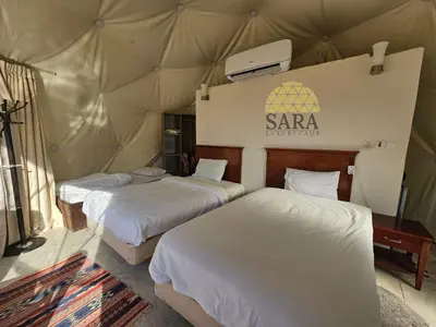 two beds in a room with a tent at SARA lUXURY CAMP in Wadi Rum