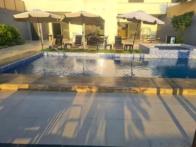 a swimming pool with tables and umbrellas and chairs at Zoom Chalets in Amman