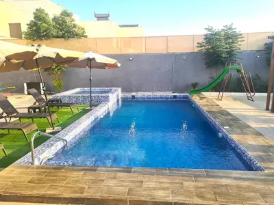 a swimming pool with a slide and a playground at Zoom Chalets in Amman