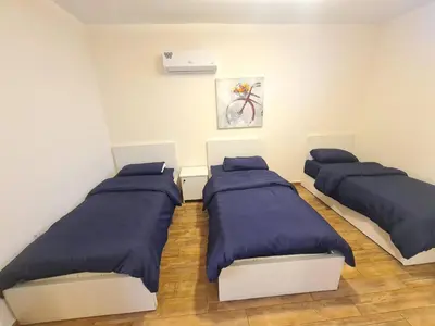 two beds in a room with blue pillows at Zoom Chalets in Amman