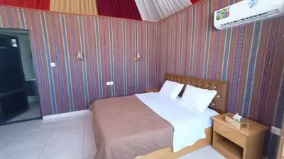 a bedroom with a bed and a tv in it at The sun of Wadi Rum camp in Wadi Rum