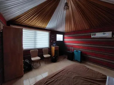 a bedroom with a red and white striped wall at The sun of Wadi Rum camp in Wadi Rum