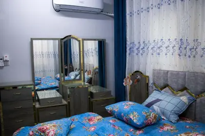 a bedroom with a bed and a dresser and mirrors at Blue House in Aqaba