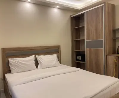 a bedroom with a bed and a book shelf at Aster Hotel Aqaba in Aqaba