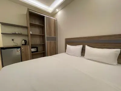 a bedroom with a large white bed with two pillows at Aster Hotel Aqaba in Aqaba