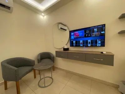 a room with a tv and a chair and a mirror at Aster Hotel Aqaba in Aqaba